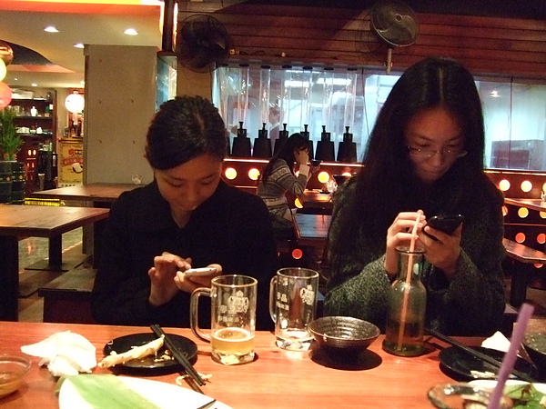 兩個人都很專心在玩iphone