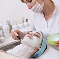 woman-applying-a-face-mask-to-a-client_1122-1352