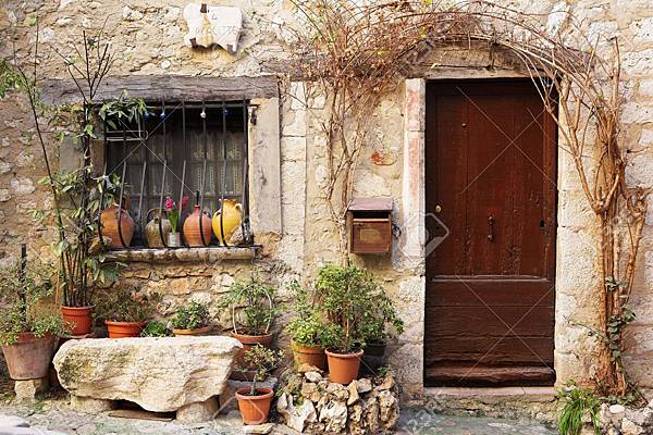 2871633-Street-garden-with-Street-name-and-potted-plants-in-front-of-windows-and-doors-in-the-quaint-little--Stock-Photo.jpg