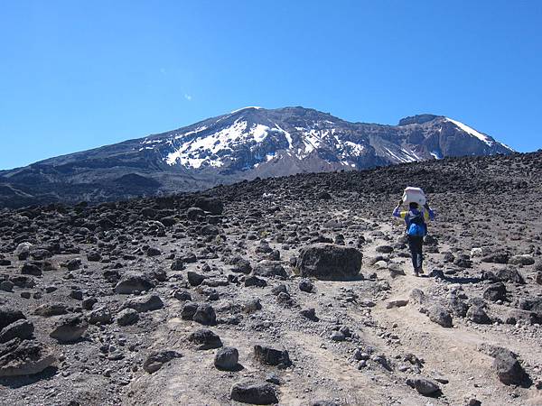 以麻布袋”頭頂揹負法”的揹工,與最高峰Uhuru peak