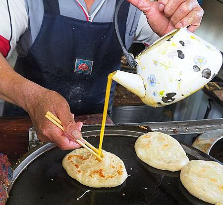台中東勢特色美食老祖灌蛋餅，欣賞老闆正在把蛋液灌進煎過的餅之中。