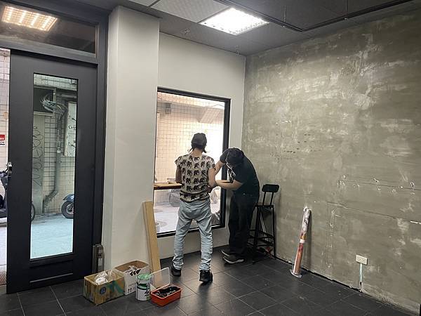 照片是屋特與育生在大窗戶前裝釘架子