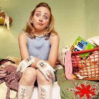 Woman-sitting-on-bed-in-messy-room