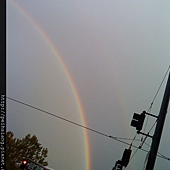 It's rainbow in front of the gray sky.