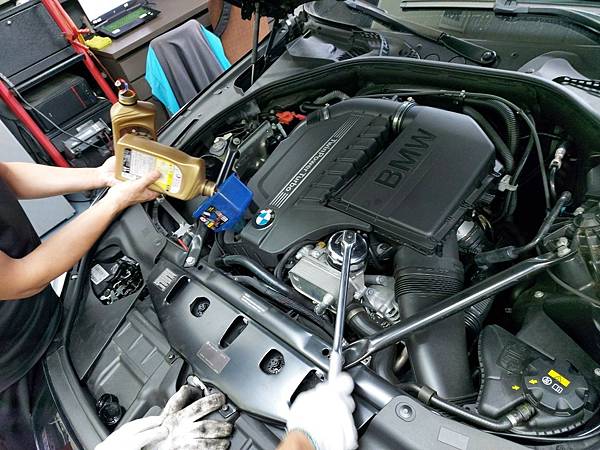 今日因為車子較少，所以一位師父負責倒入機油、另一位師父安裝機油濾芯新品 ，速度上會比以往來的快速 。