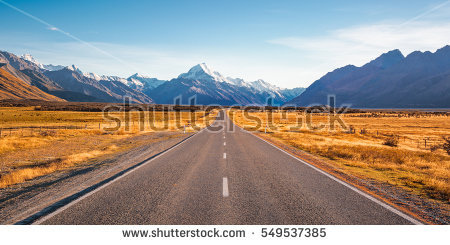 stock-photo-a-long-straight-road-leading-towards-a-snow-capped-mountain-in-new-zealand-549537385.jpg