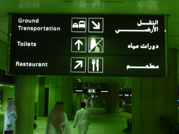 沙烏地阿拉伯-男生服裝與機場內方向指示牌.jpg