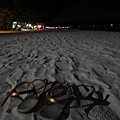 赤腳走在夜晚的沙灘
