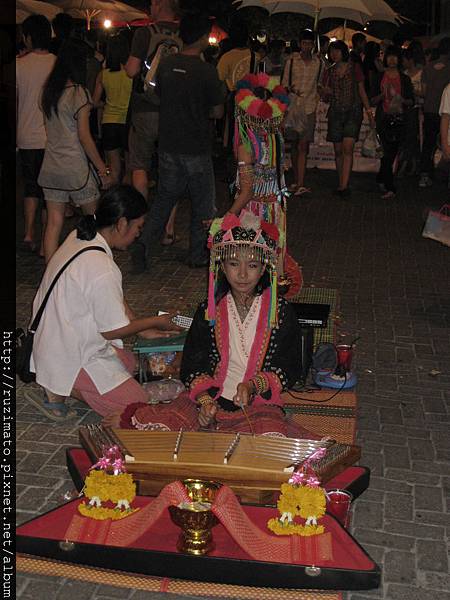 Girl performs in Chiang Mai Sunday Market with tribal folk apparel