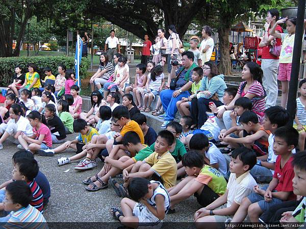 學生、家長、公園人潮紛紛坐下來欣賞孩子們精采的演出