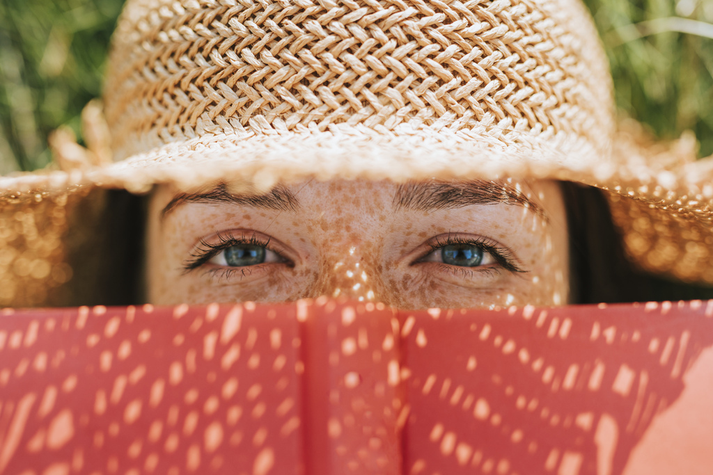 closeup-woman-covering-her-face-with-red-book.jpg