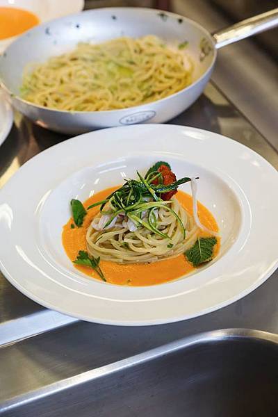 Spaghetti quadrati with garlic, extra virgin olive oil with raw squid, zucchini and bloody San Marzano