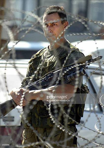 26th August, 2003. A Russian soldier guards the entrance to a Chechen government building..jpg