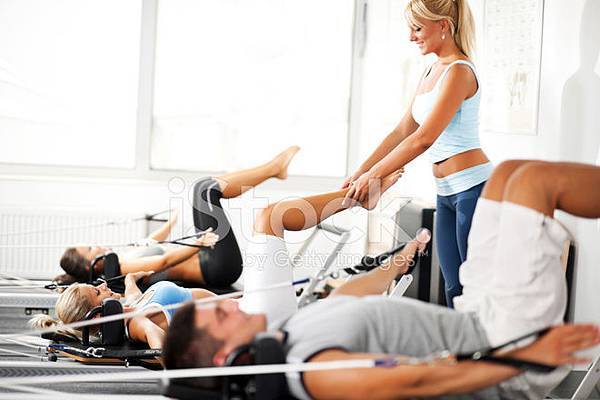 18395542-coach-assisiting-the-girl-exercising-on-pilates-machine.jpg