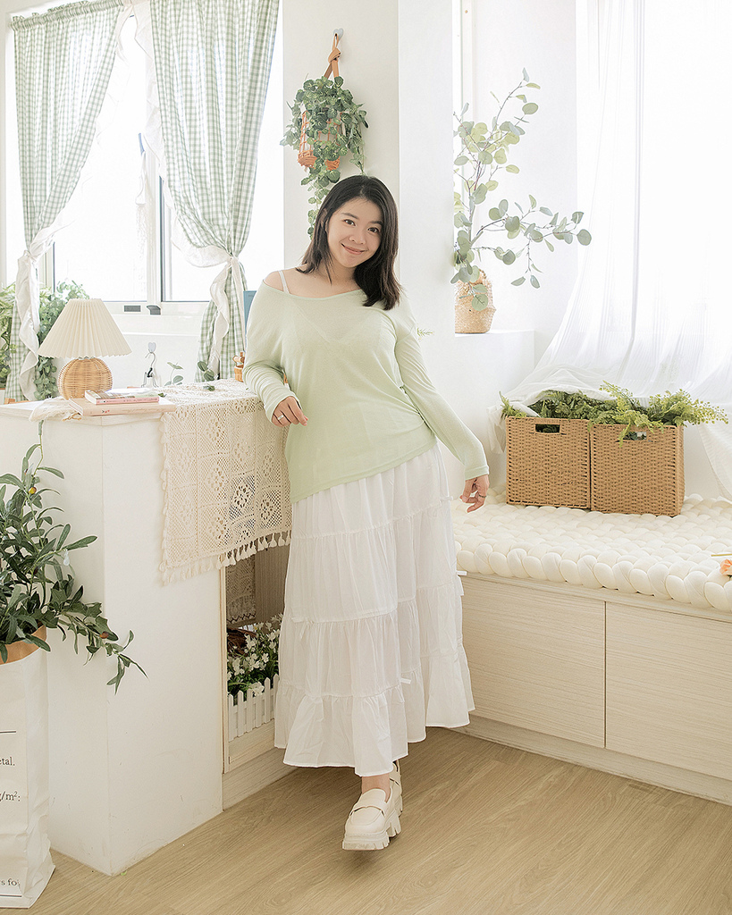 棉花糖女孩穿著薄荷綠長袖針織上衣與白色層次感長裙，搭配白色厚底鞋，站在自然元素環繞的房間中，展現夏季穿搭的清新日系風格