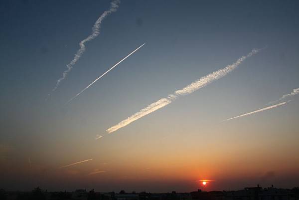 黃昏的天空，多條飛機凝結雲。