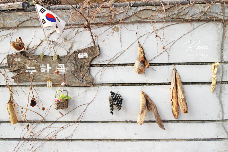 젖은 고구마 말라빠진 과일로 장식된 서촌 주택의 고벽.