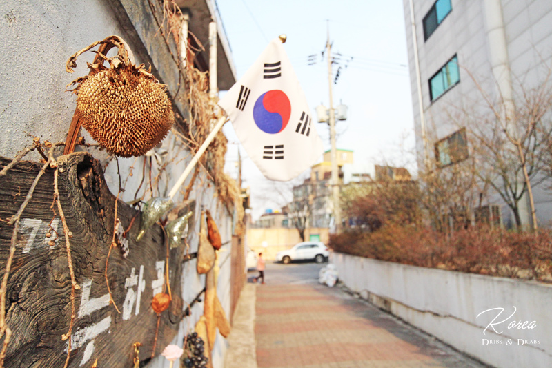 서촌의 아늑한 대로, 겨울 끝자락의 바람에 흔들리는 큰 나무들의 실루엣.