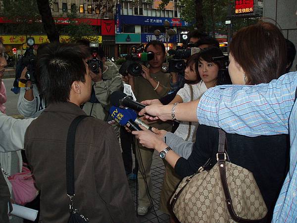 記者採訪中，背對鏡頭者為台中上來的郭先生